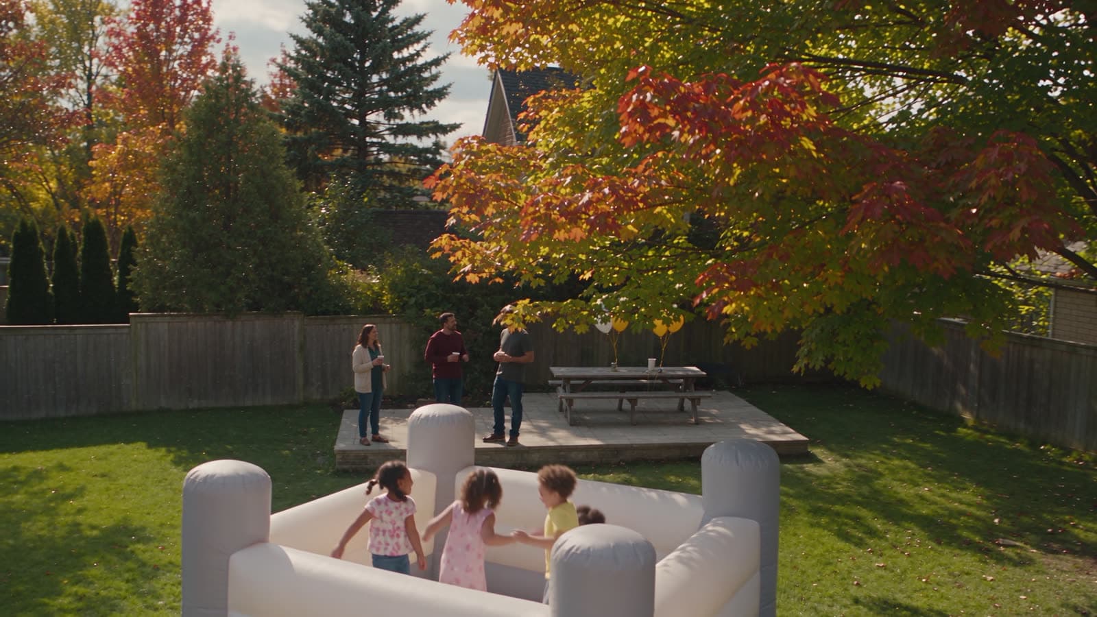 White bounce castle set up in a fenced backyard