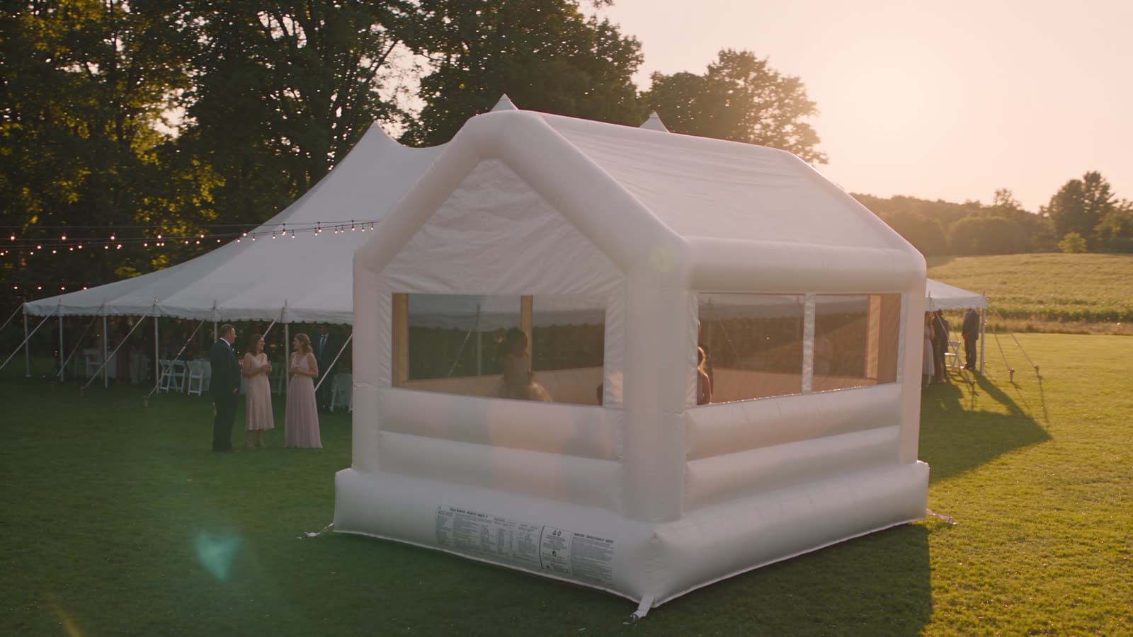White bounce house at a garden wedding